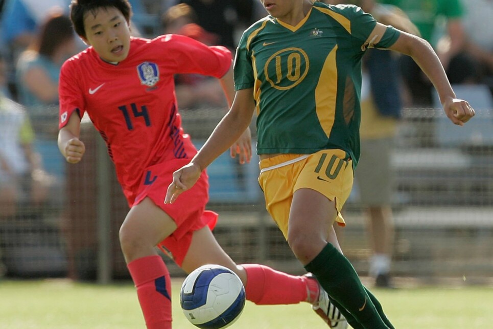 SYDNEY, AUSTRALIA - JANUARY 17:  Kyah Simon (R) of Australia runs with the ball ahead of Soojung Lee (L) of South Korea during the 2007 Australian Youth Olympic Festival soccer match between Australia and South Korea at Valentines Sports Park January 17, 2007 in Sydney, Australia.  (Photo by Corey Davis/Getty Images)