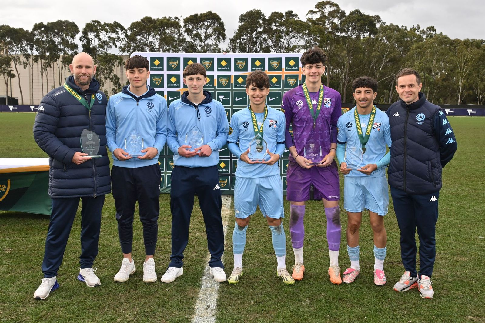a group of people standing in a field posing for the camera