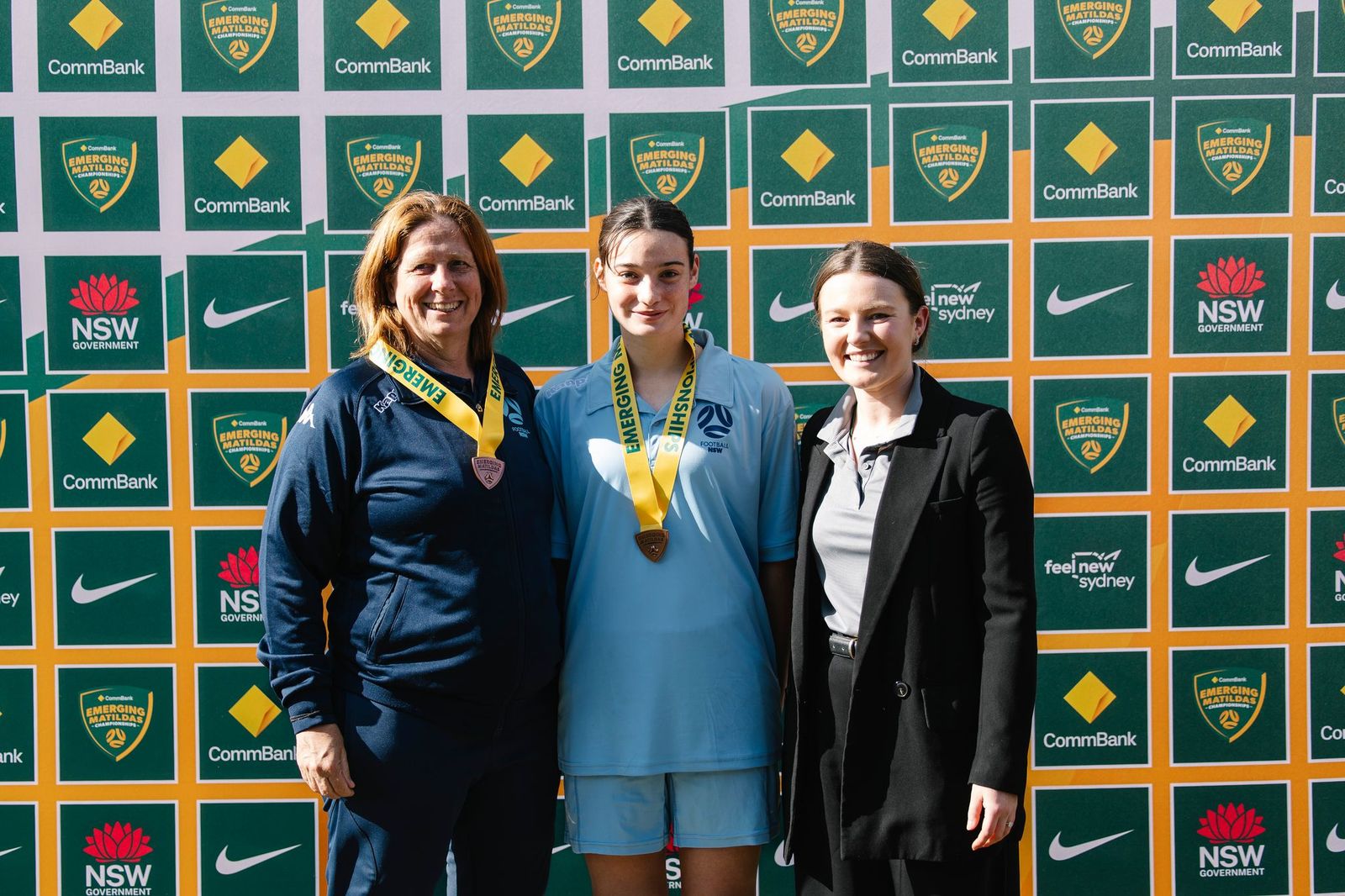 a woman standing in front of a group of people posing for the camera