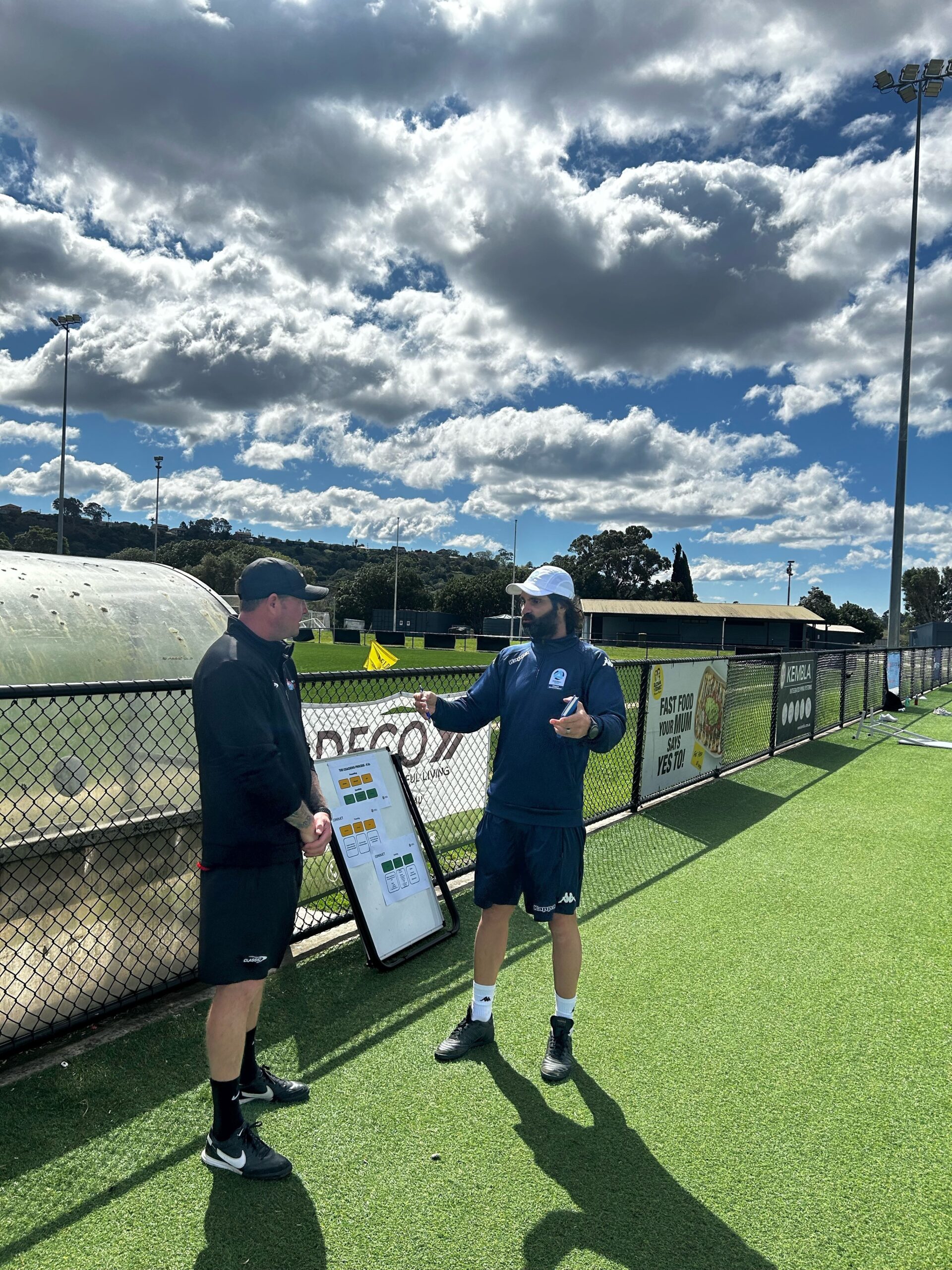 a group of people standing on top of a grass covered field