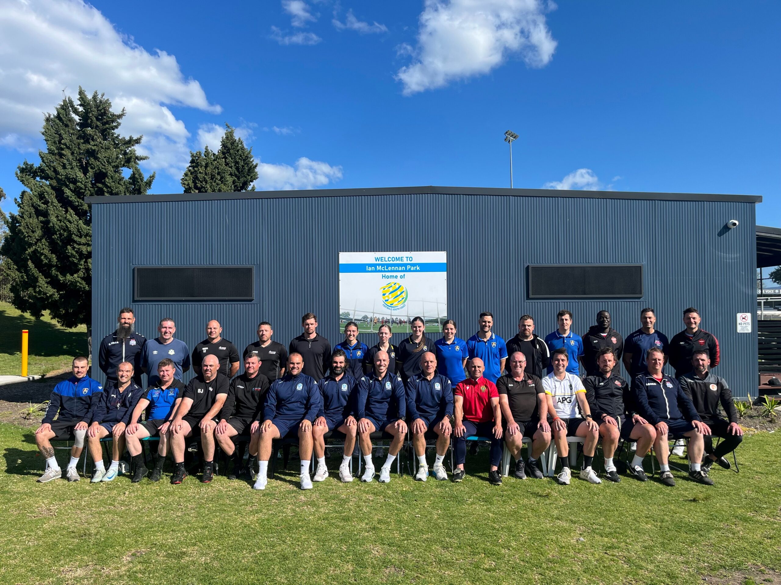 a group of people standing on top of a grass covered field