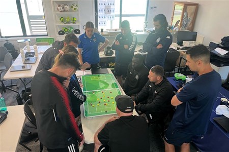 a group of people looking at a computer