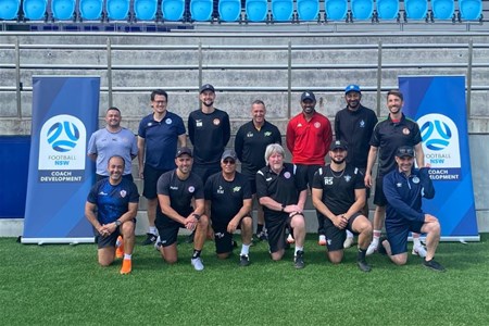 a group of people posing for the football ball