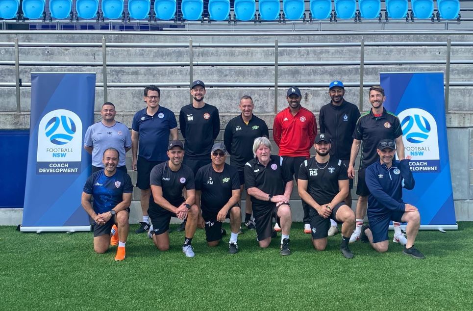 a group of people posing for the football ball