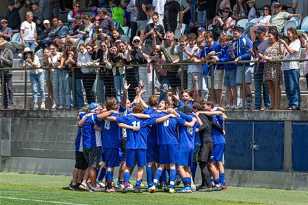 a group of people watching a football ball in front of a crowd