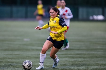 a young girl playing football on a field
