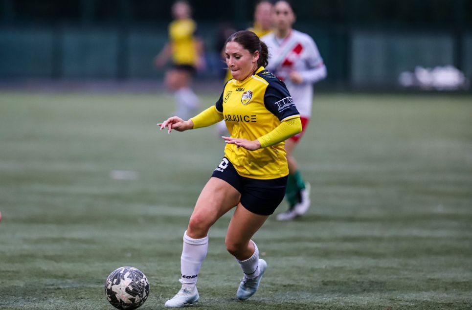 a young girl playing football on a field