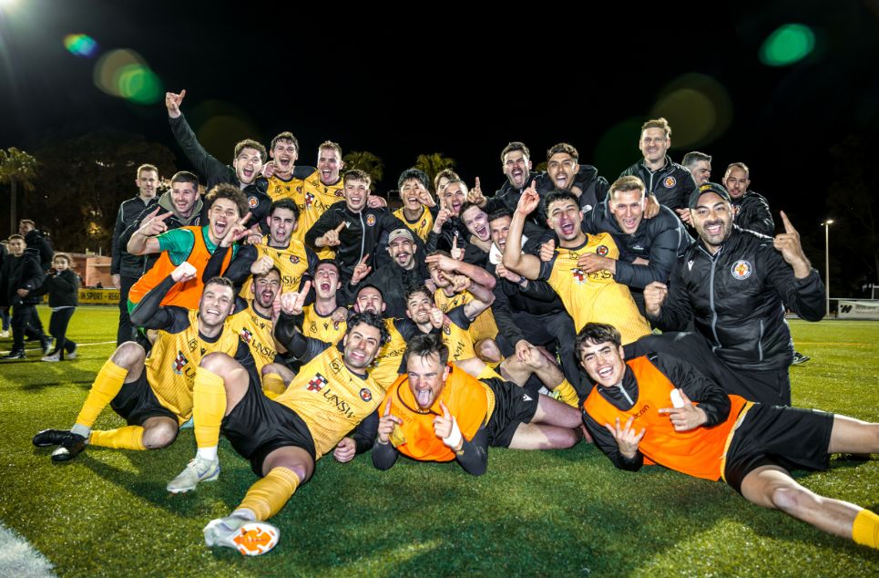 a group of people posing for the football ball