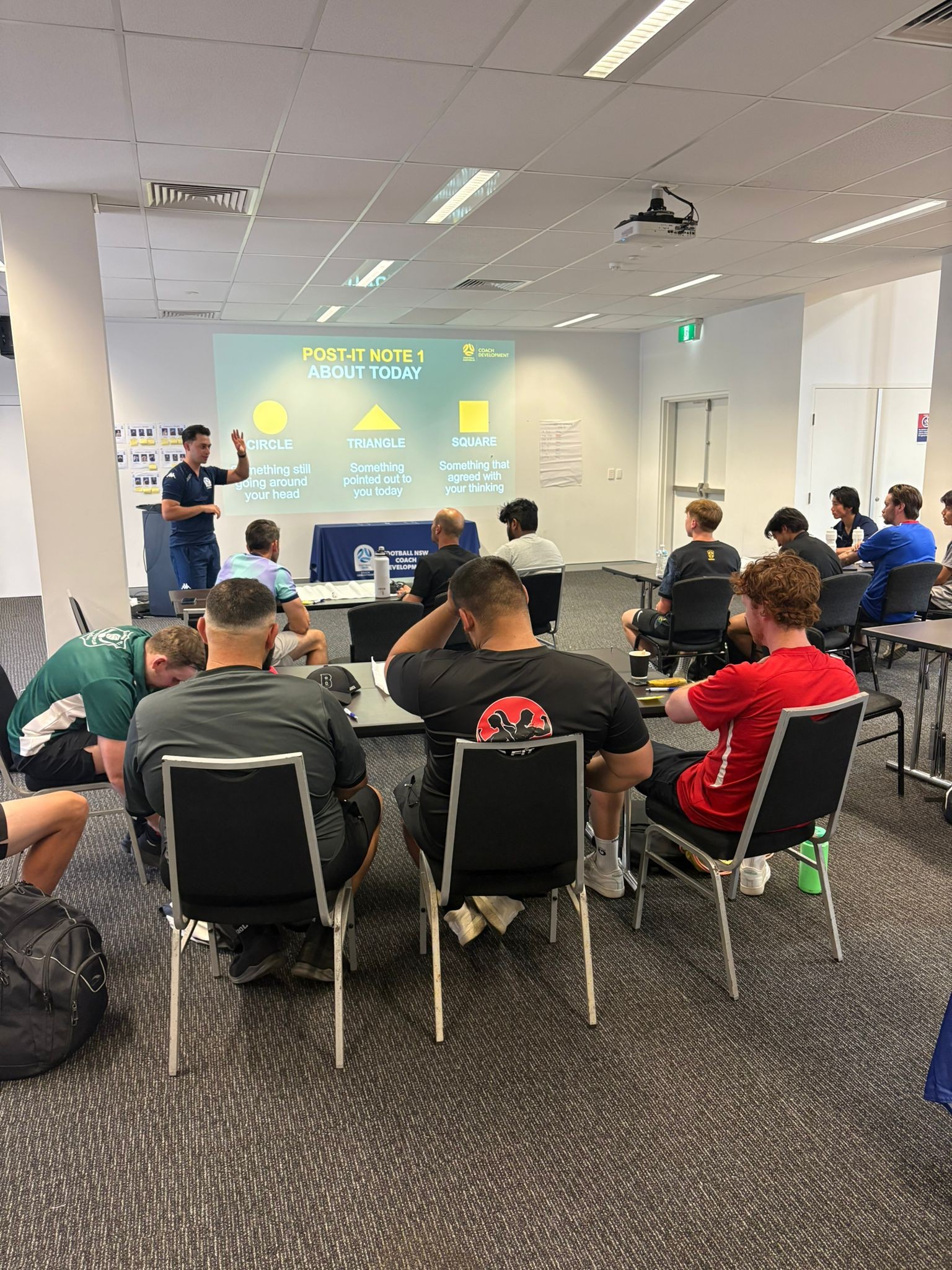a group of people sitting at desks in a room