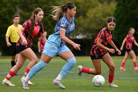 a young girl playing football on a field