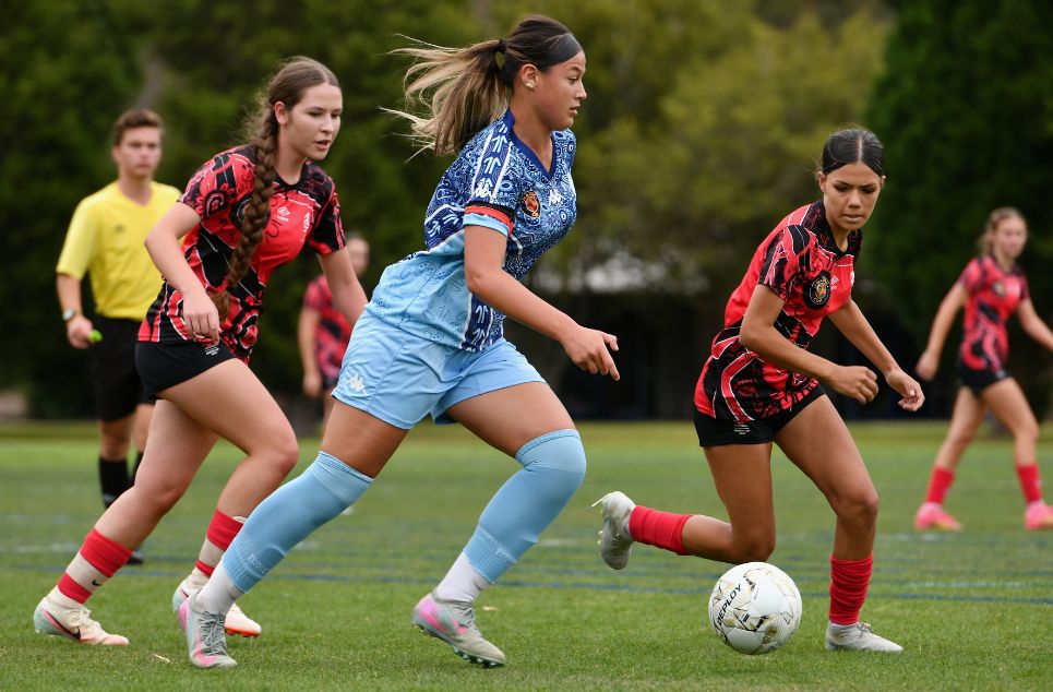 a young girl playing football on a field
