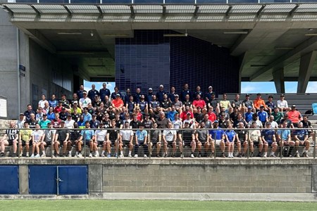 a group of people watching a fence and building