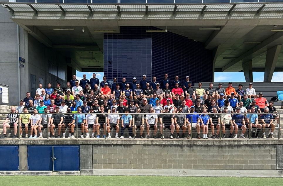 a group of people watching a fence and building