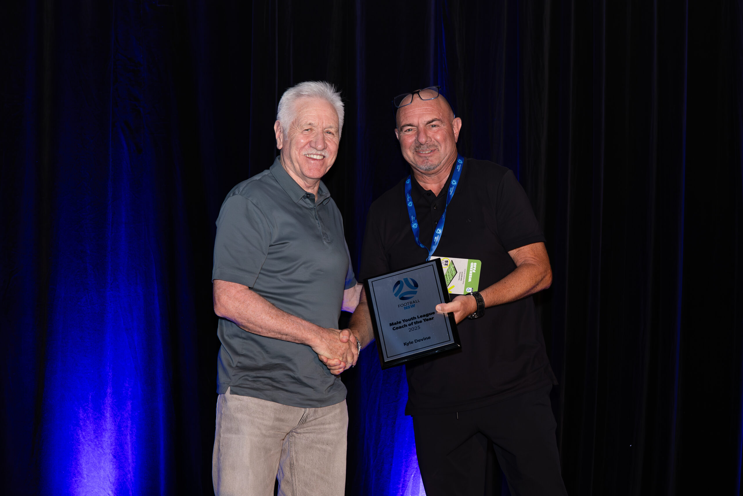 a man standing on a stage in front of a curtain
