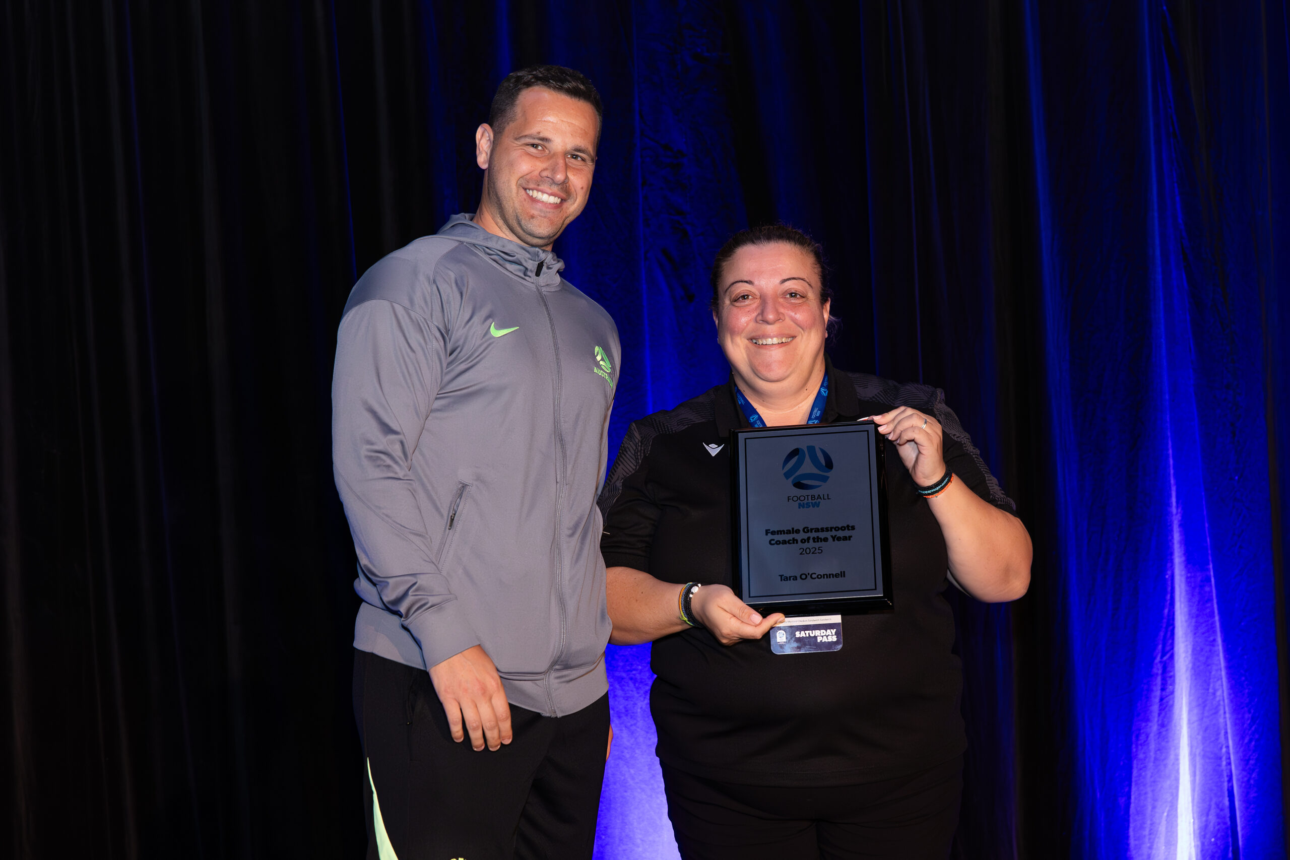 a man standing on a stage in front of a curtain