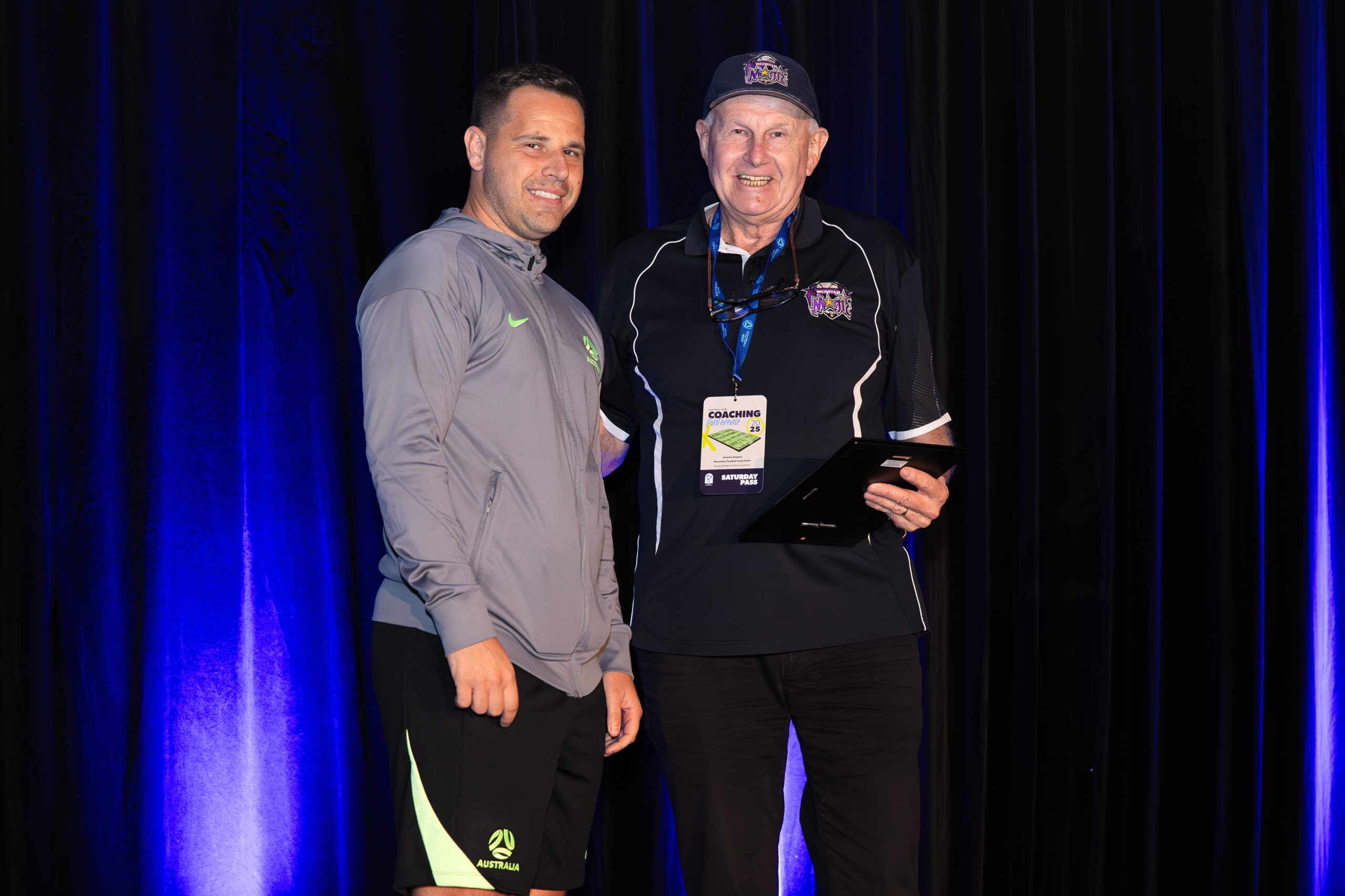 a person standing on a stage in front of a curtain