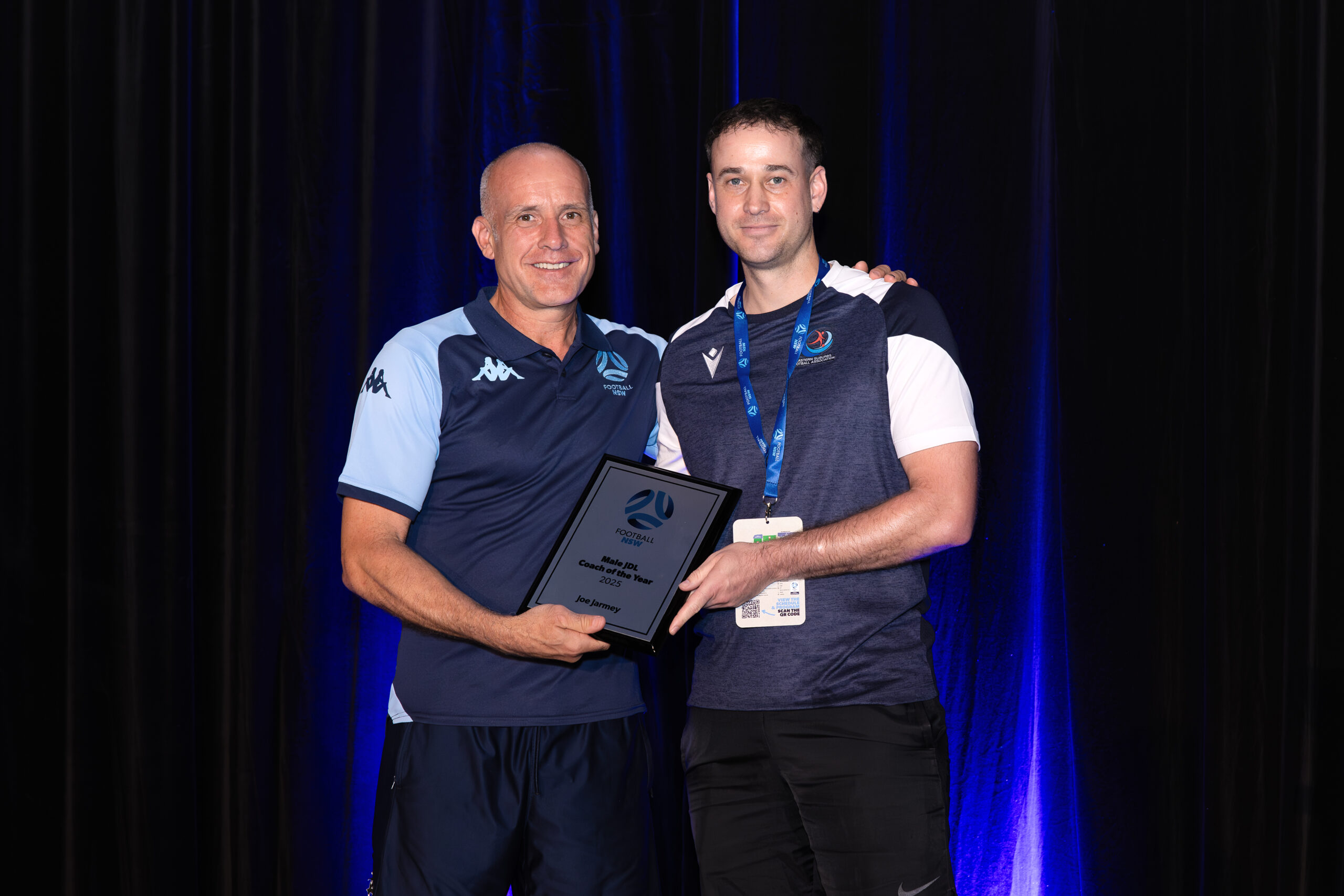 a man standing on a stage in front of a curtain