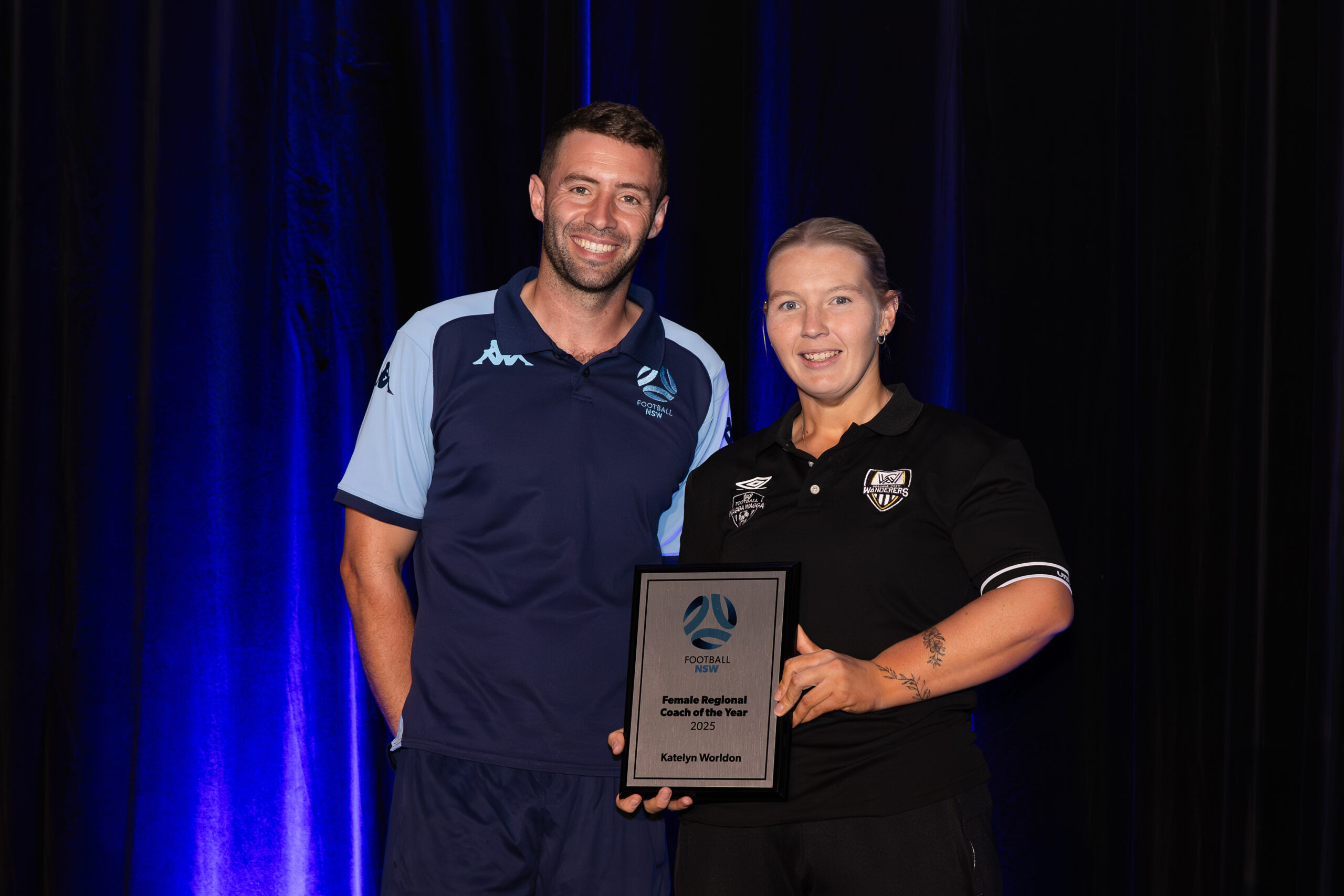 a man standing on a stage in front of a curtain