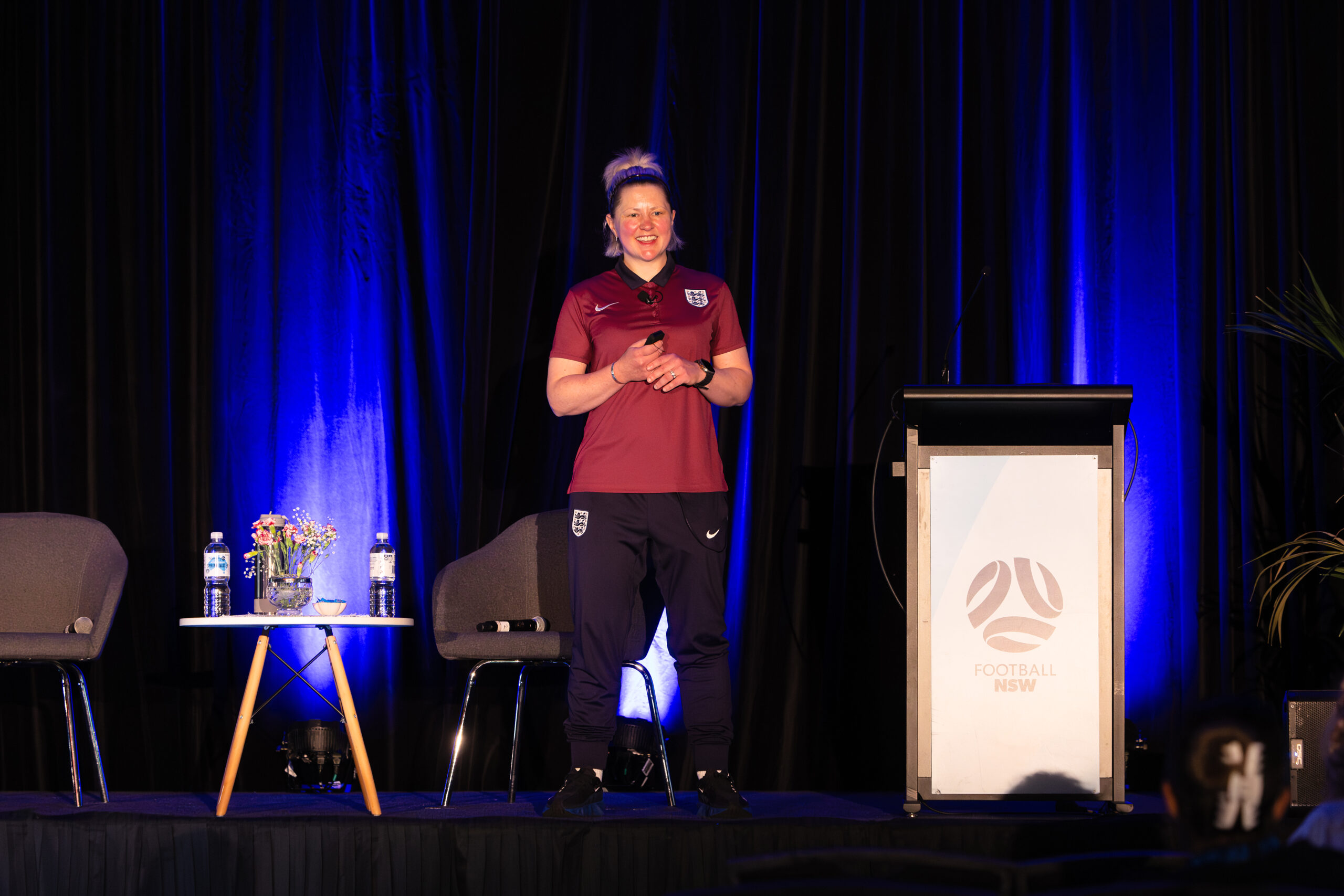 a man and a woman standing on a stage in front of a curtain