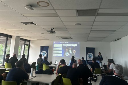 a group of people sitting at a table in front of a computer