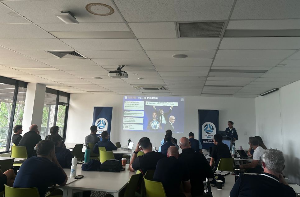 a group of people sitting at a table in front of a computer