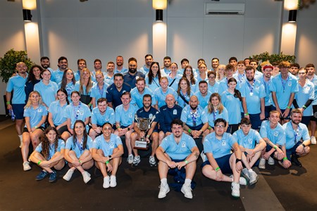 a group of people standing in front of a crowd posing for the camera