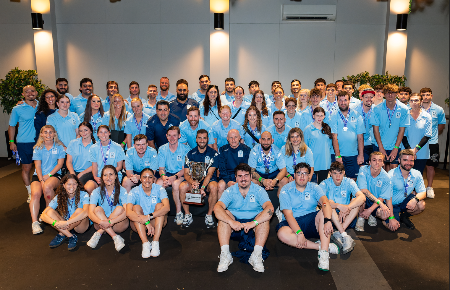 a group of people standing in front of a crowd posing for the camera