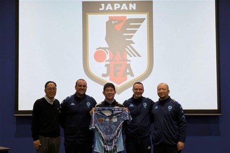 a man standing in front of a group of people posing for the camera
