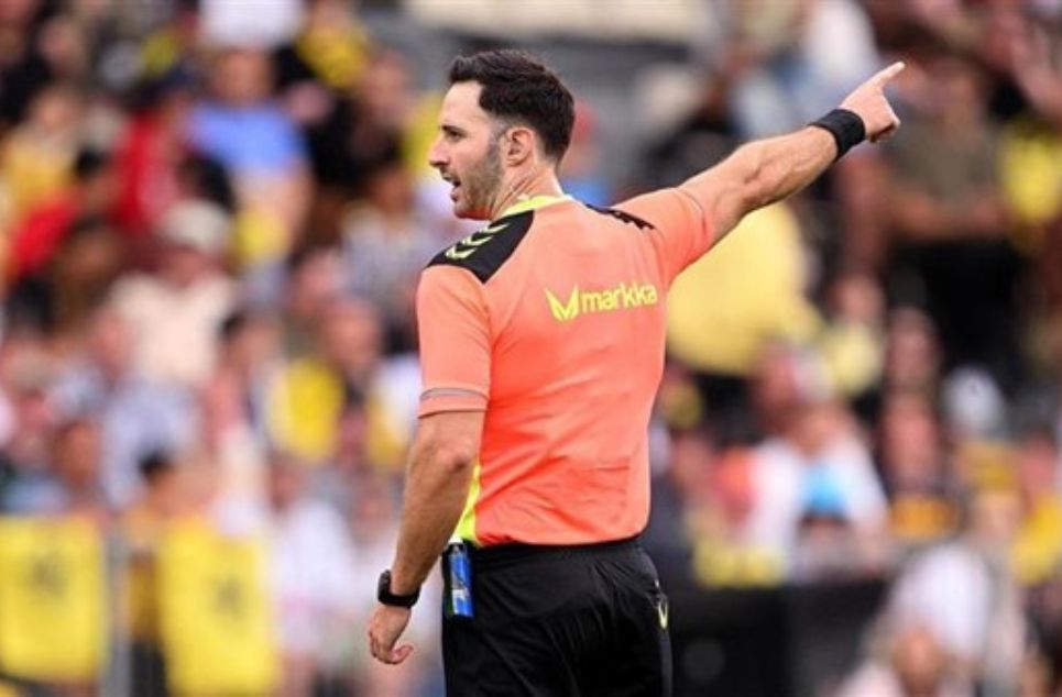 a man holding a football ball in front of a crowd