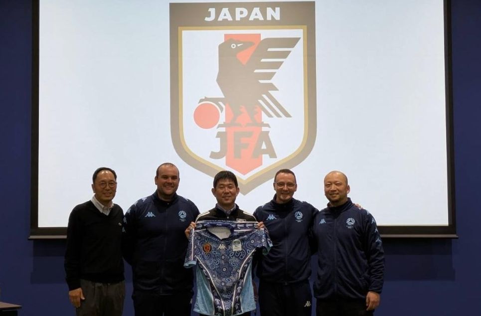 a man standing in front of a group of people posing for the camera