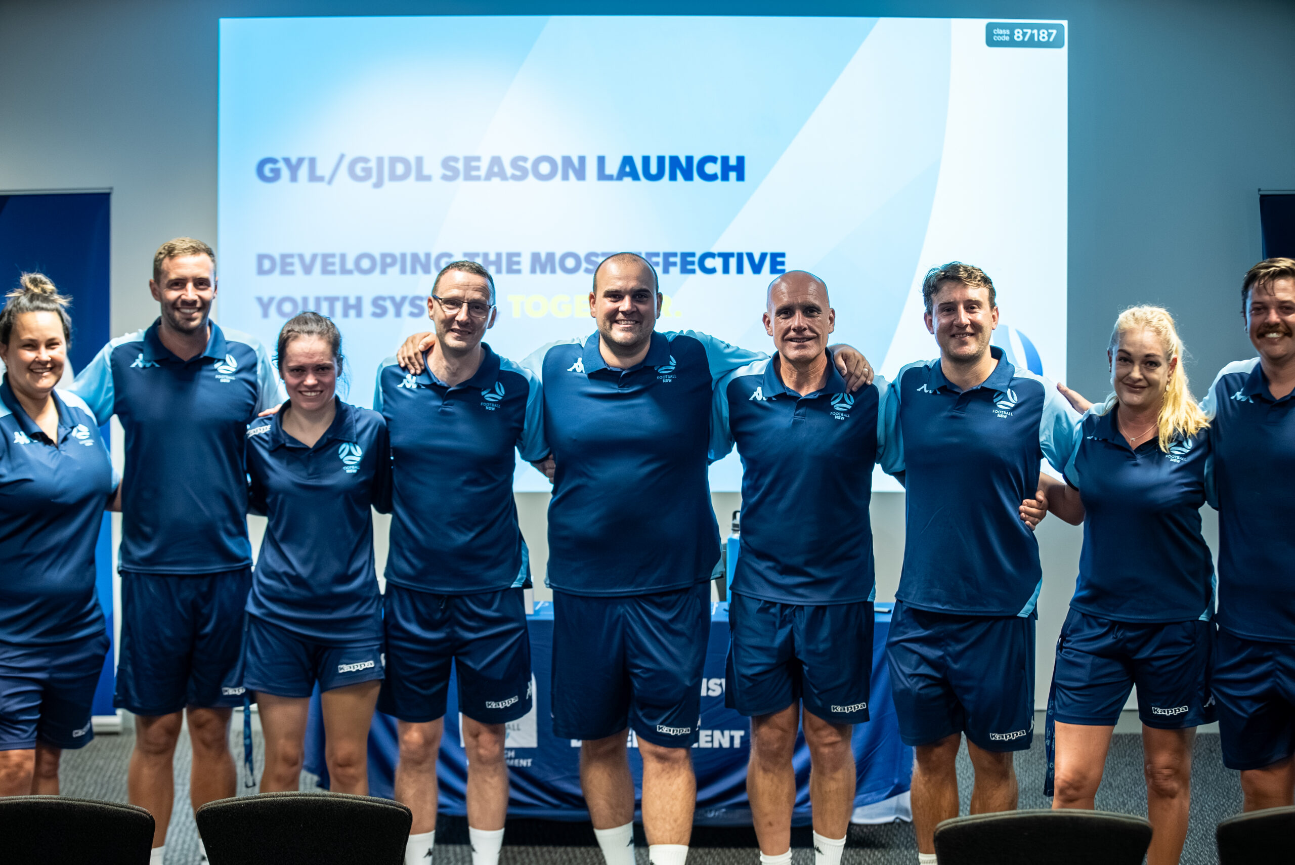 a group of people standing in front of a crowd posing for the camera