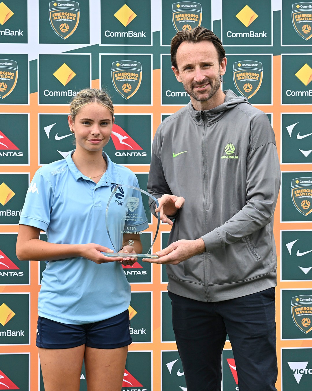 a group of people standing around a sign posing for the camera