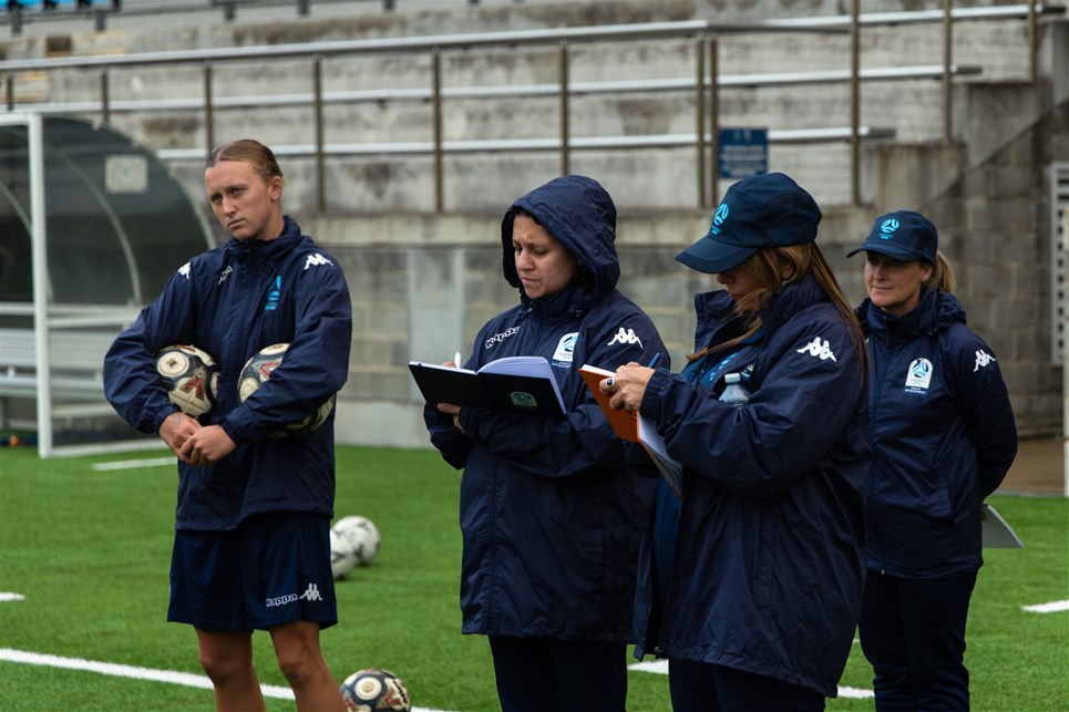a group of people standing next to a football ball