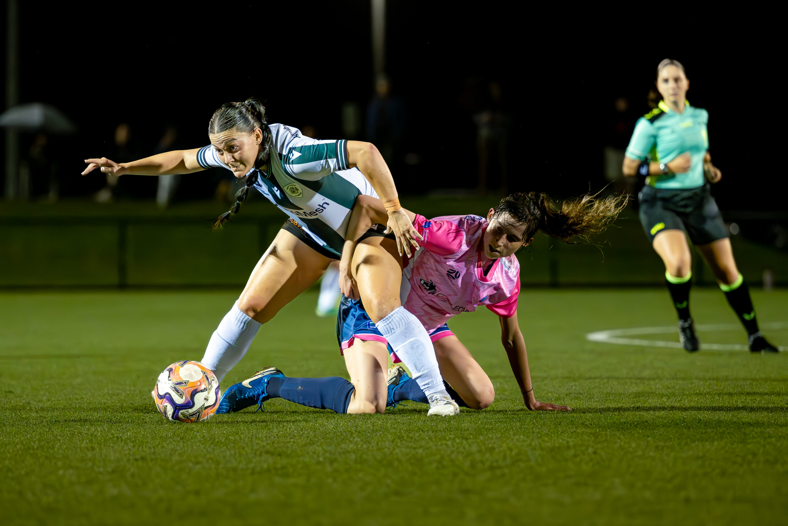 a girl holding a football ball on a field