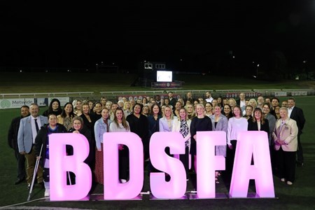 a group of people standing in front of a crowd posing for the camera