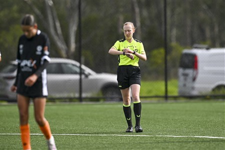a young girl playing football on a field