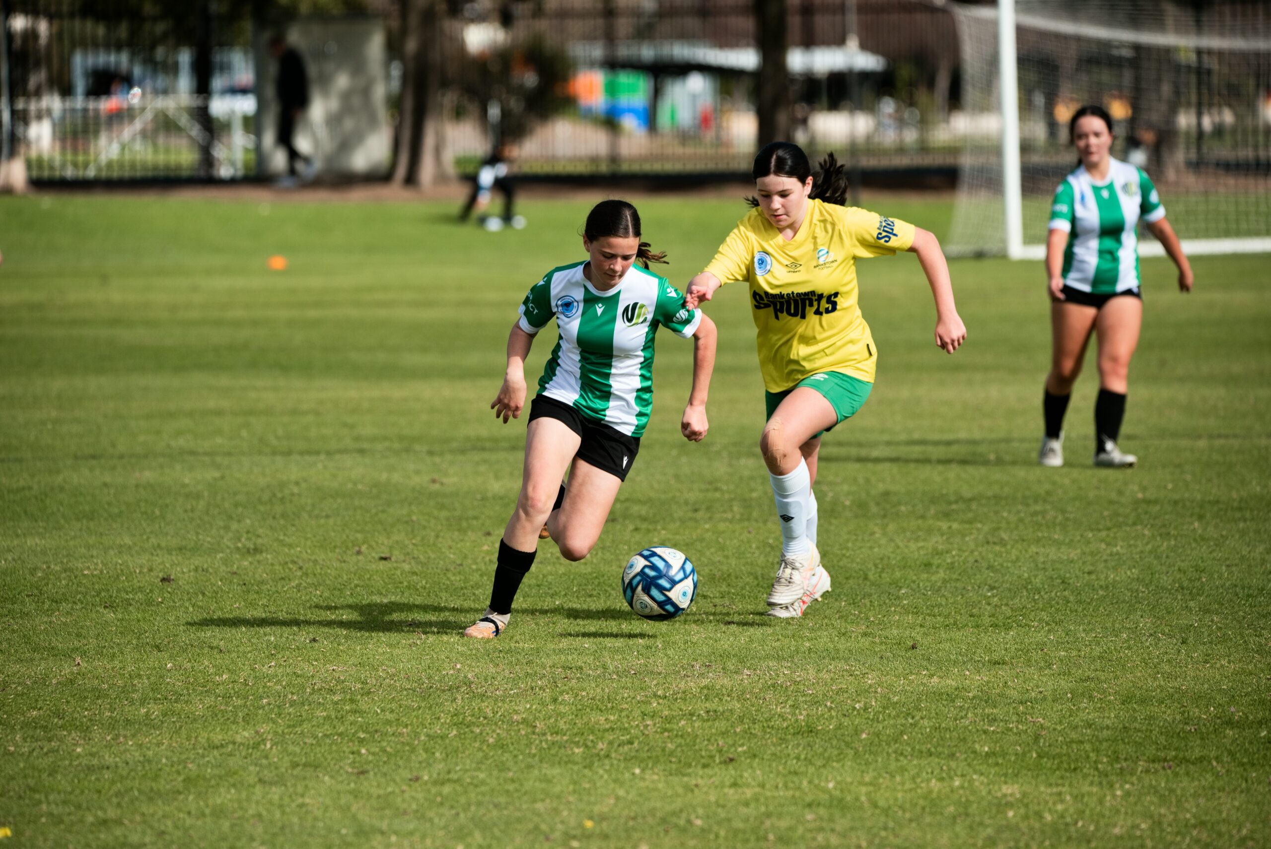 a young girl playing football on a field