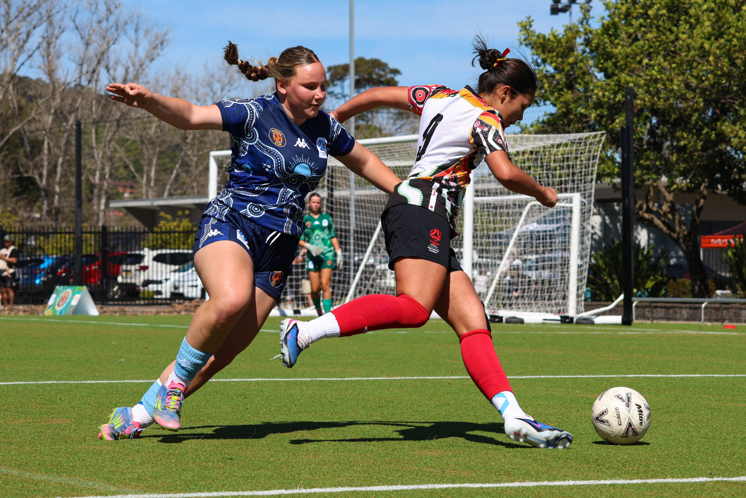 a young girl playing football on a field