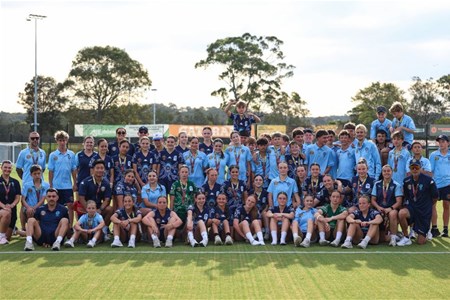 a group of people standing in front of a crowd posing for the camera