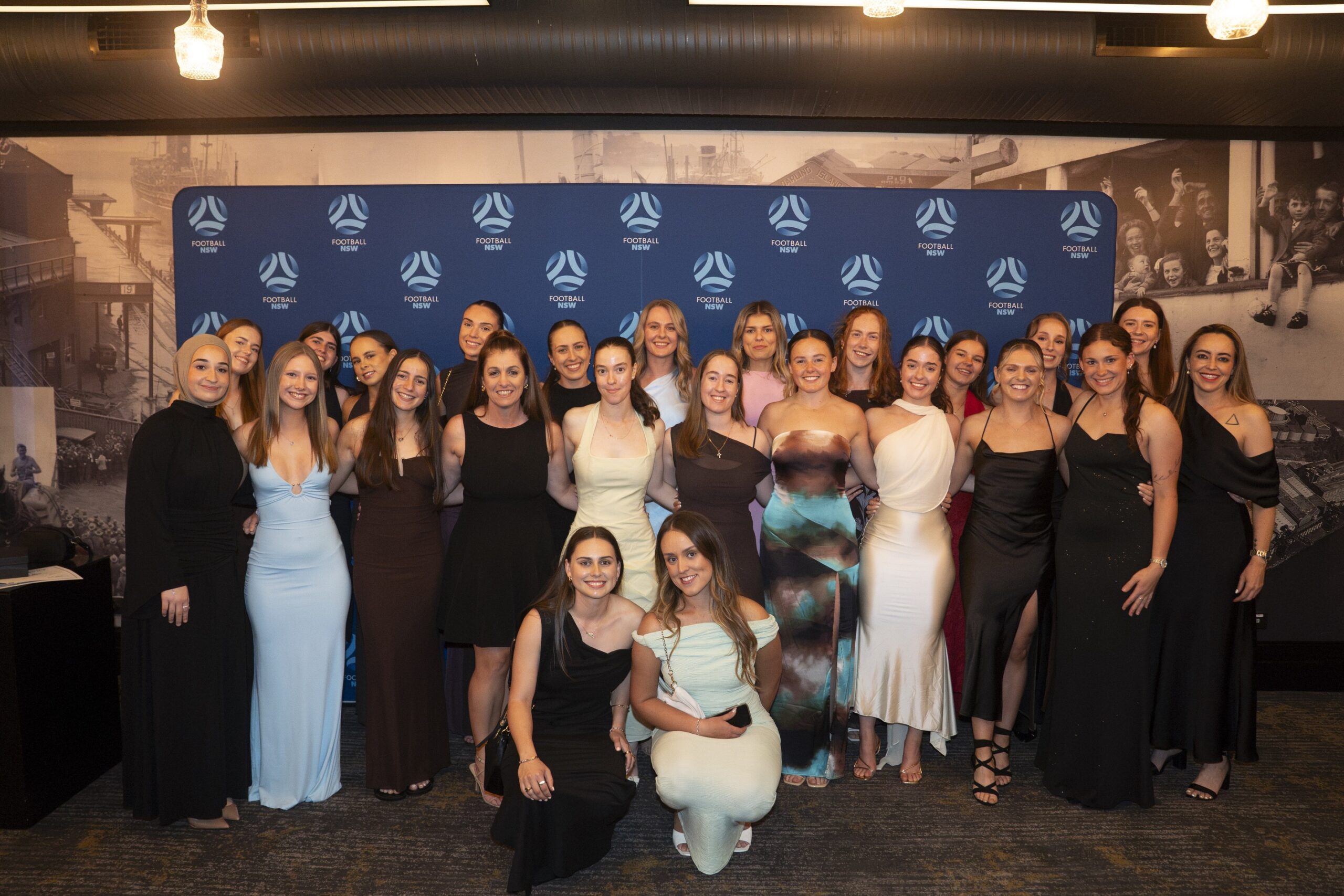 a group of people standing in front of a crowd posing for the camera